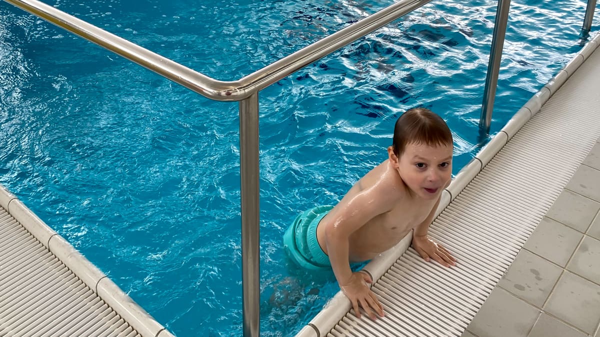 Pieni poika nousemassa uima-altaasta.