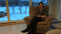 Anne Ukkonen istuu nojatuolissa ikkunan edessä kotonaan Luumäellä.