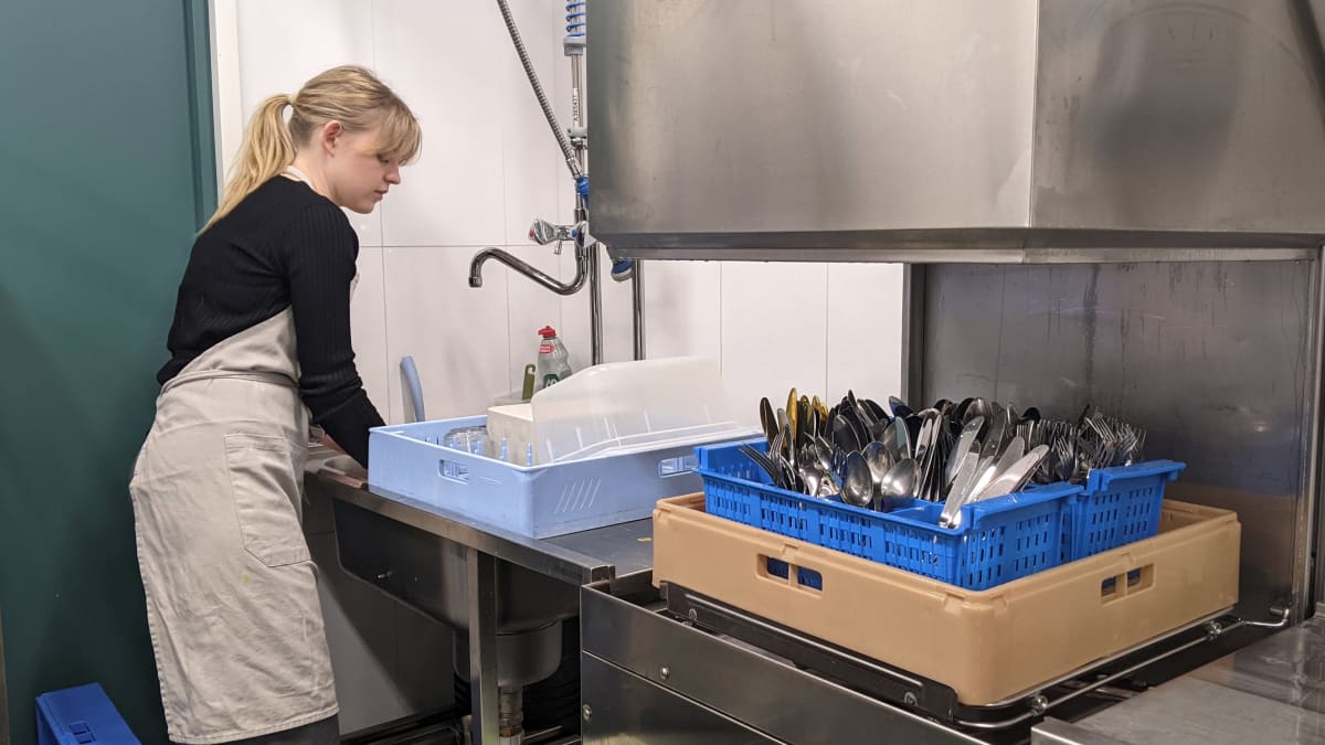 Cafe Bruketin tarjoilija Emmi Pörhölä pesee astioita.