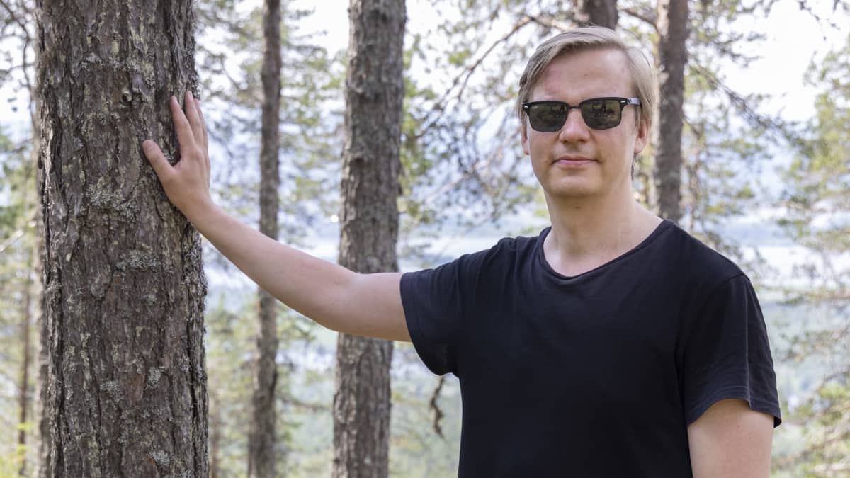 Aawastock -festivaalin promoottori Tommi Lankko Aavasaksan huipulla nojaa puuhun.