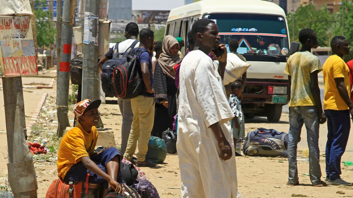 Ihmiset odottavat bussia paetakseen Etelä-Khartumista 18. huhtikuuta.