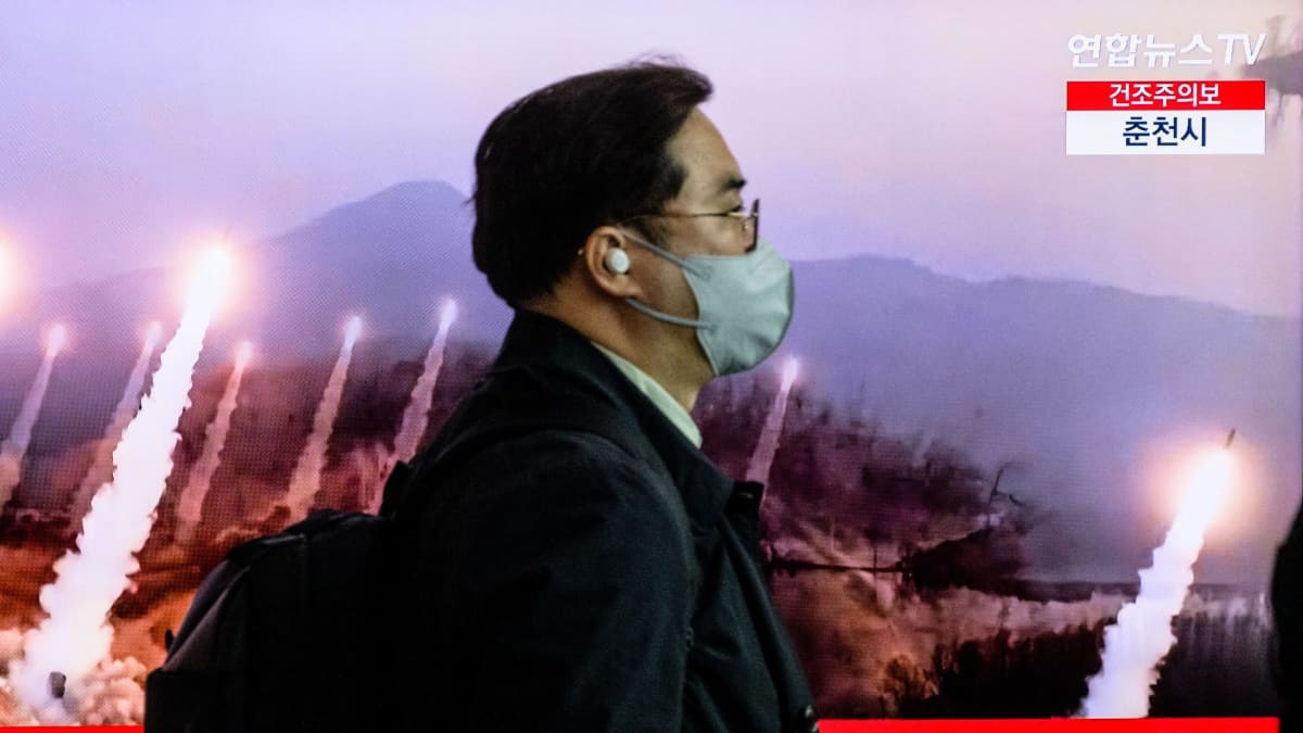 Mies kävelee television ohi, jossa näkyy uutislähetys Pohjois-Korean ohjuskokeesta.