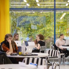 Opiskelijoita Jyväskylän yliopiston kirjastorakennuksen kahvilassa.