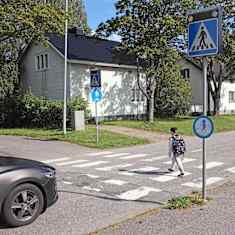Koululainen ylittää tietä Harjun koulun lähettyvillä Pieksämäellä. Suojatiemerkissä vilkkuvalot.