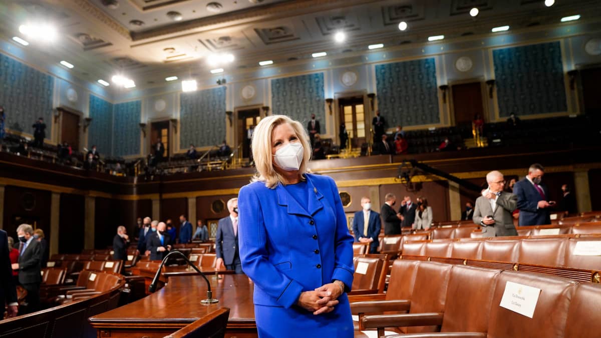 Maski kasvoillaan oleva Liz Cheney seisoo yksin kongressin istuntosalissa.