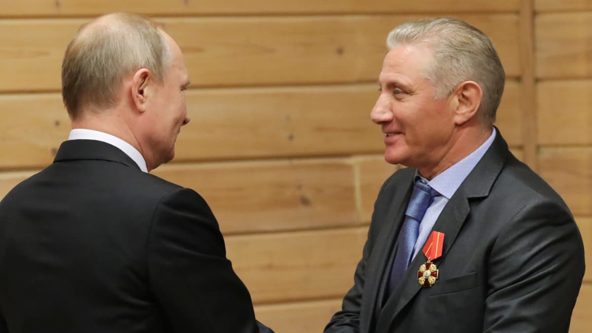 Vladimir Putin ja toinen mies kättelevät ystävällisen näköisesti.