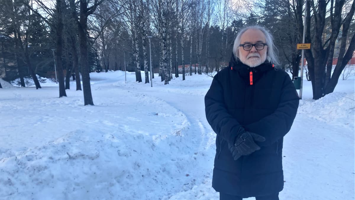 Muusikko Esa Kotilainen seisoo talvisessa puistossa.