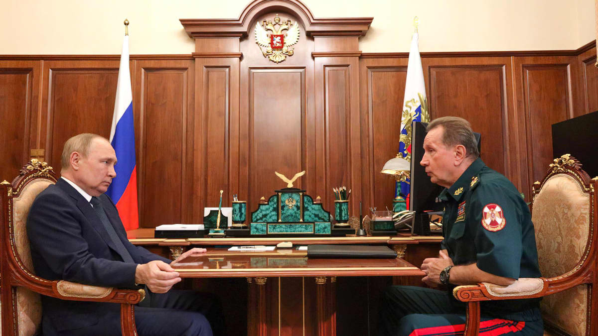 Vasemmalla Putin ja oikealla kansalliskaartin komentaja Viktor Zolotov univormussa, istuvat vastakkain pöydän ääressä. 