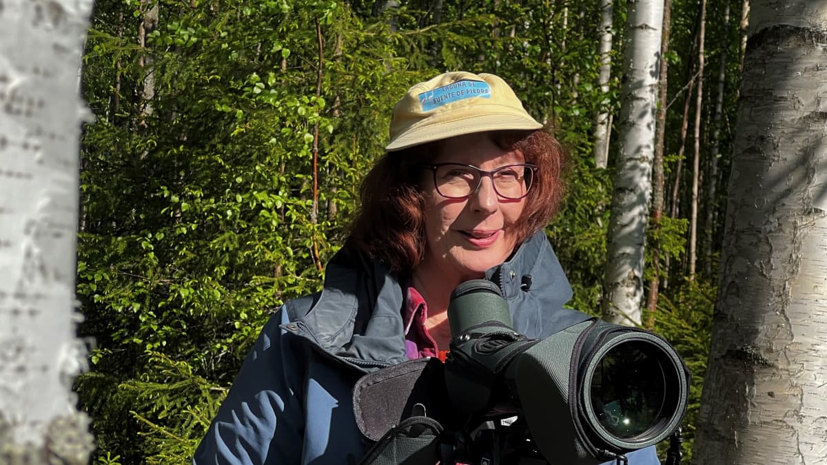 Krisiina Järvenpää tarkkailee luontoa kaukoputken ja kameran kanssa omalla pihamaallaan.