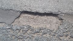 Kadun tai tien pinnassa asfalttivaurio. 