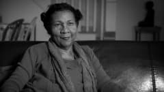 Gloria Jean Watkins istuu sohvalla.