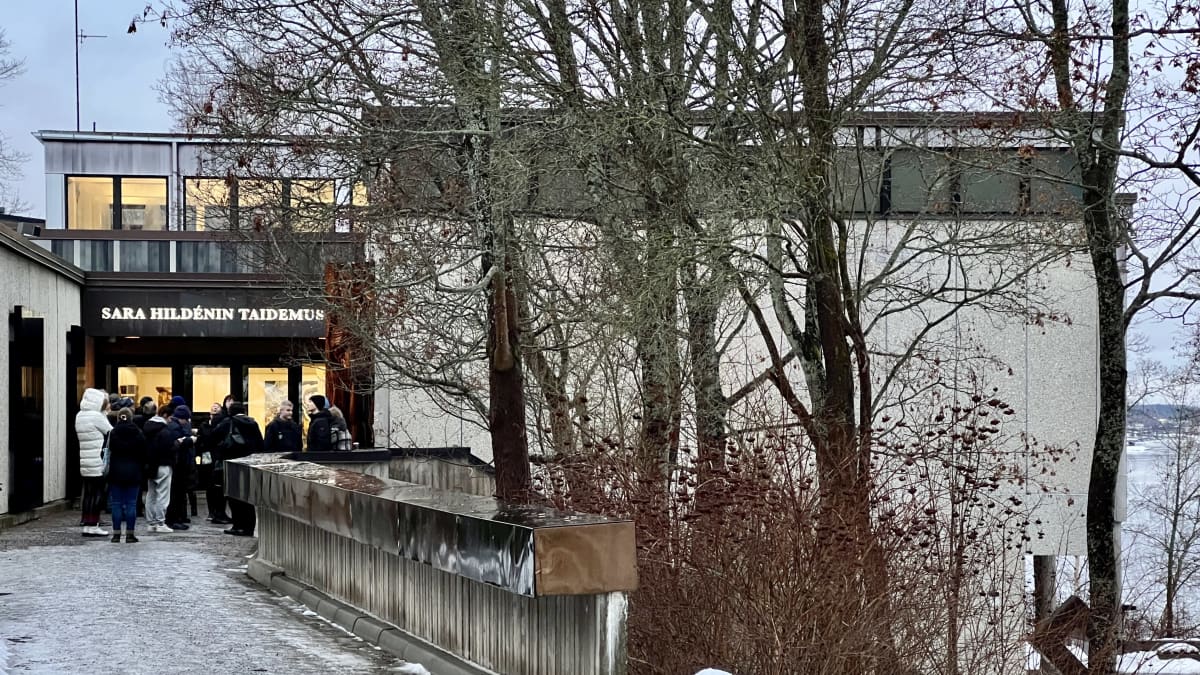 Sara Hildénin taidemuseon sisäänkäyntiä kuvattuna ennen museon aukeamista. Ovella ihmisiä odottamassa sisäänpääsyä.