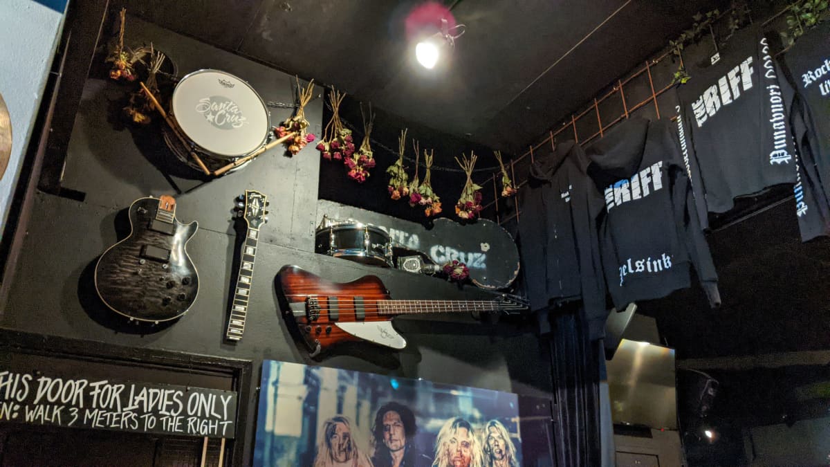 Erilaisia soittimia ja mainospaitoja The Riff -baarin seinällä.