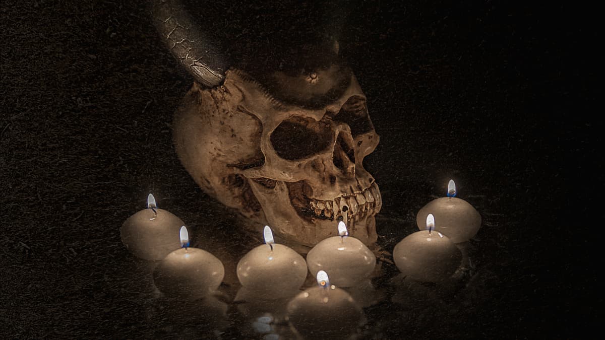 Pääkallo, jossa sarvet ja kynttilöitä ympärillä.