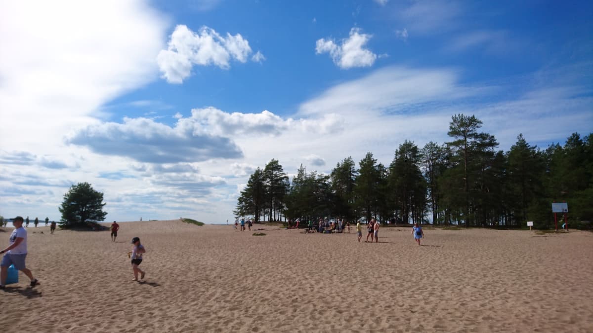 Ihmisiä Ärjänsaaren hiekkarannalla.