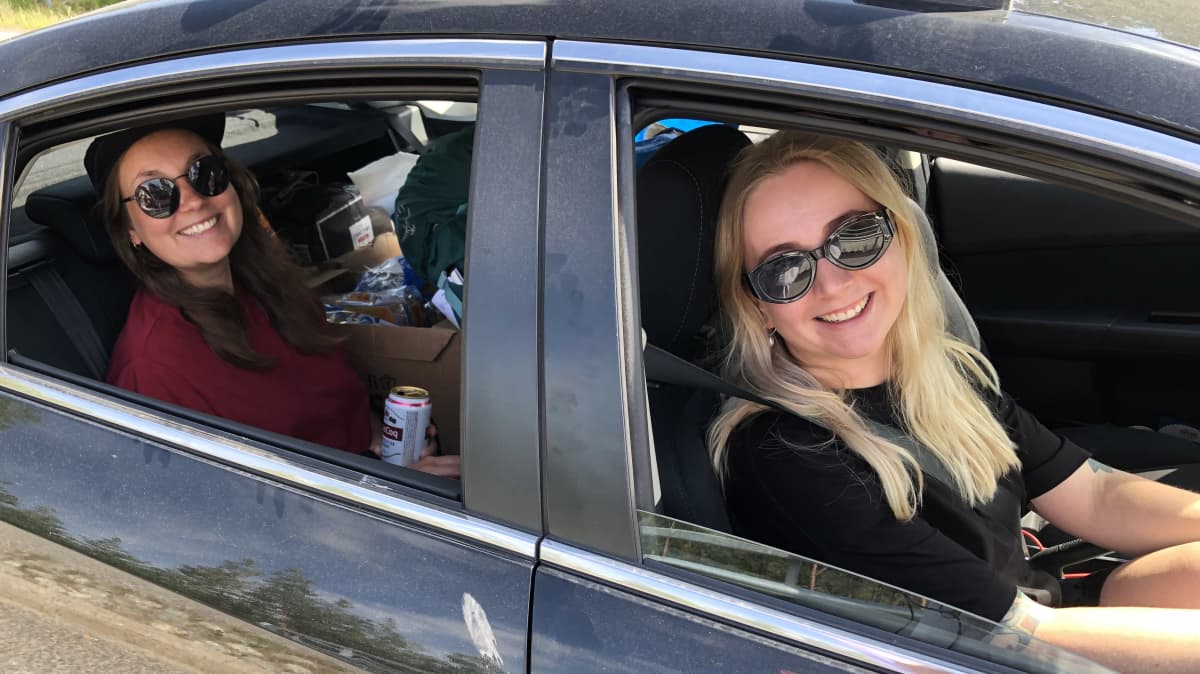 Kaksi naista hymyilee autossa matkalla juhannuksen viettoon Paraisten-Nauvon lautalla.