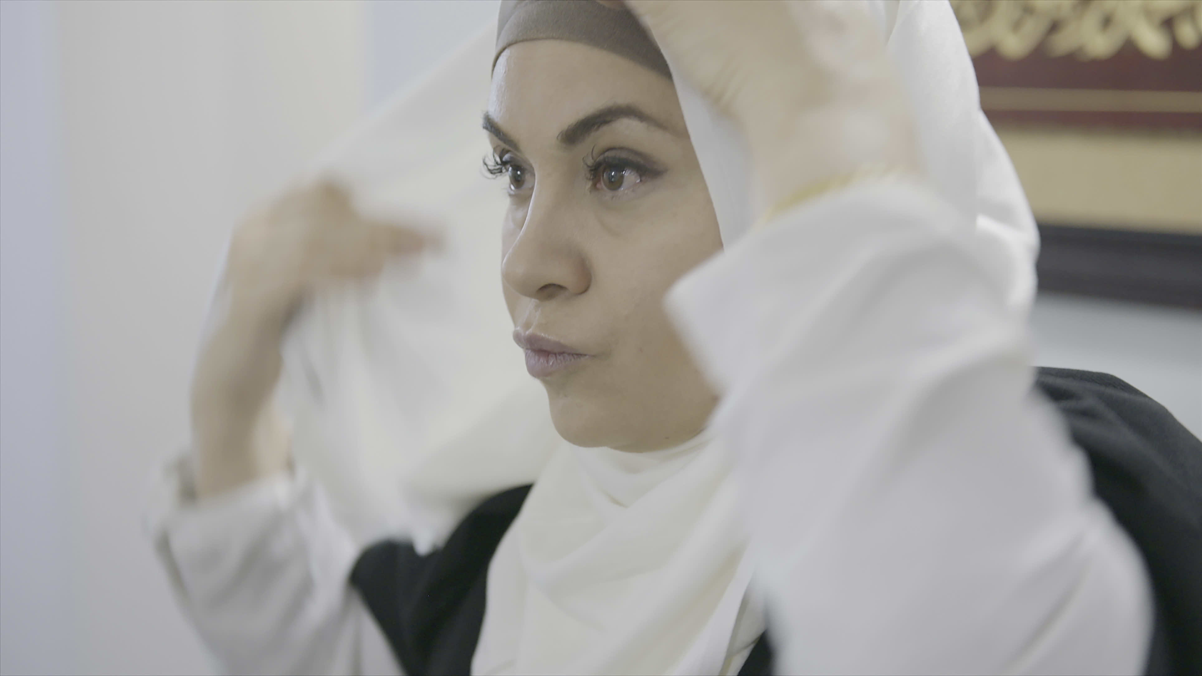 Afrah Al Bayaty asettelee valkoista hijabiaan lähikuvassa.