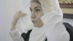 Afrah Al Bayaty asettelee valkoista hijabiaan lähikuvassa.