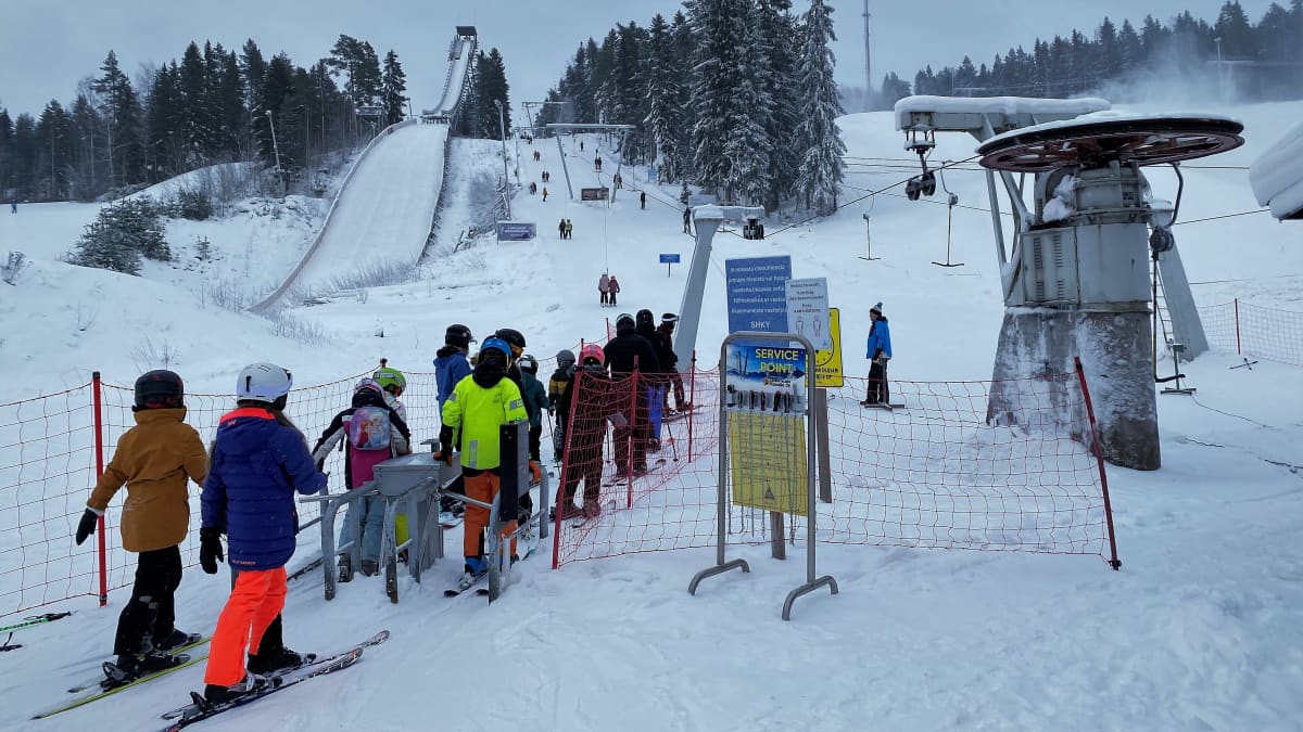 laskettelijoita hissijonossa.