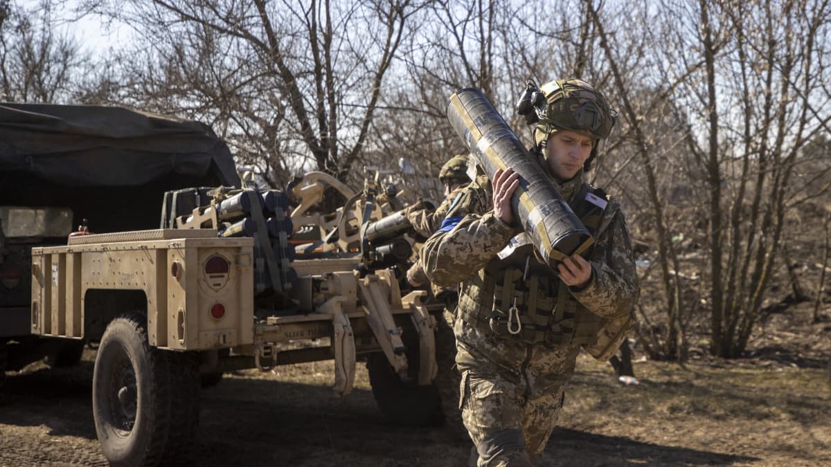 Ukrainalainen sotilas kantaa harteillaan kranaatinheittimin ammusta.