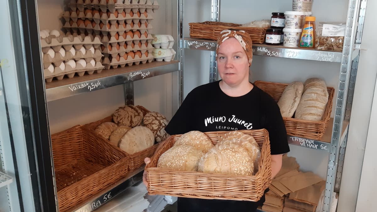 Leipomoyrittäjä Mimmi Tick pitää sylissään koria, jossa on hapanjureen leivottuja leipiä.