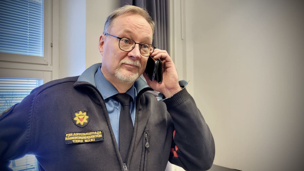 Olympimitalisti Joni Mäen isä, Tero Mäki puhuu puhelimeen yllään pelastusjohtajan univormu.