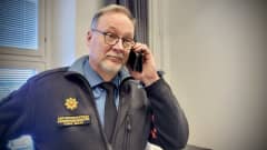 Olympimitalisti Joni Mäen isä, Tero Mäki puhuu puhelimeen yllään pelastusjohtajan univormu.