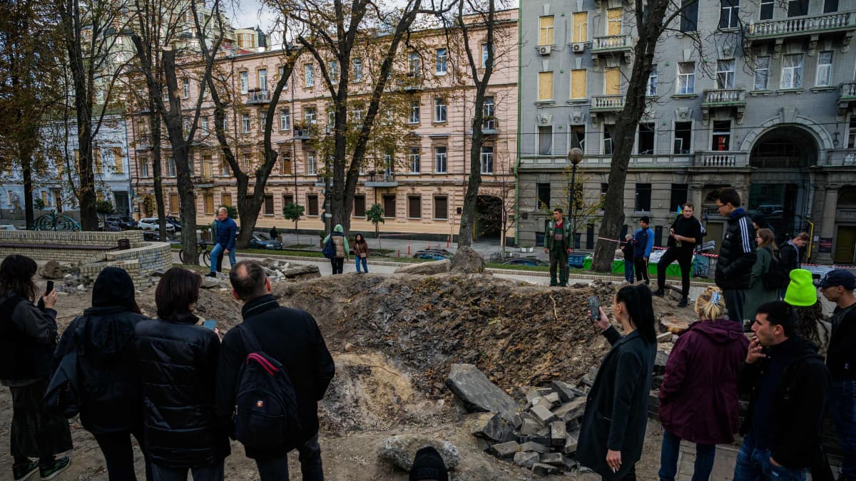 Ihmiset ovat kerääntyneet pommin kraaterin ympärille Kiovan asuinalueella.
