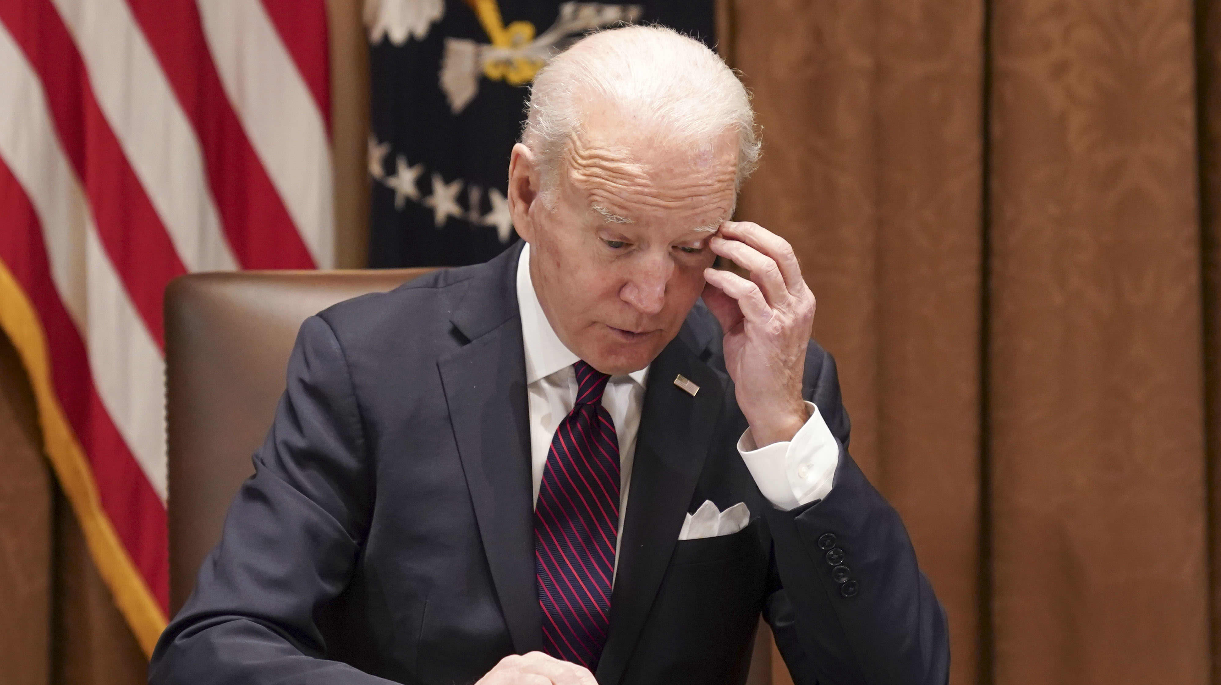 Joe Biden lukee papereita työpöytänsä ääressä huolestuneen näköisenä. 