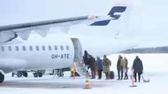 Kajaanin lentokenttä 29.12.2022. Matkustajat nousevat Finnairin potkurikoneeseen.