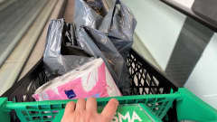 Käsi työntää Prisman ostoskärryjä. Kärryissä muovikasseja ja vessapaperipakkaus. 