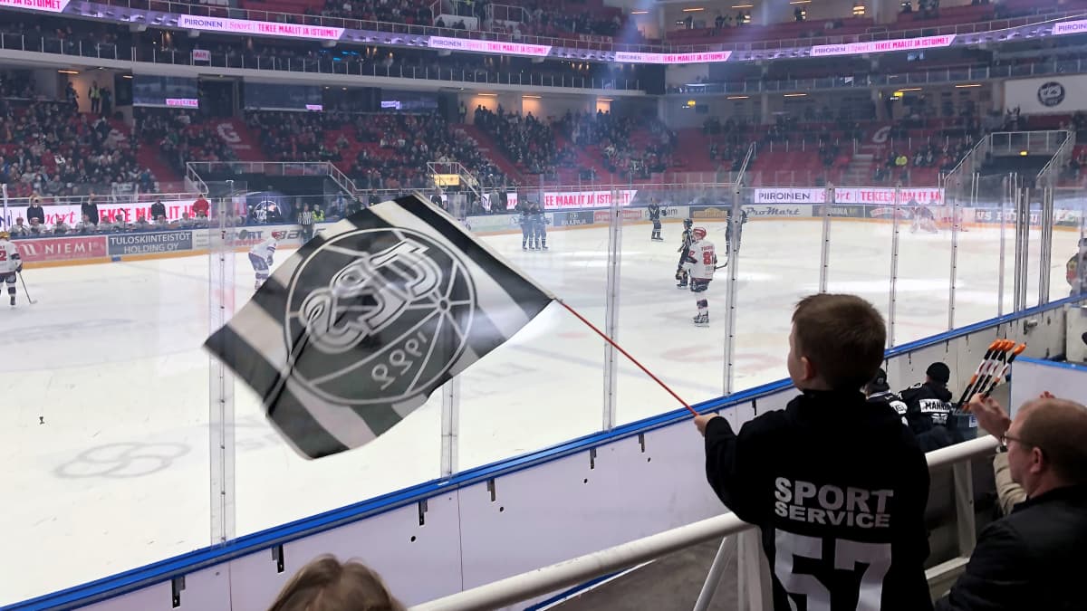 Poika heiluttaa TPS-lippua Turkuhallin katsomossa.