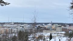Kuva talvisesta Lahden keskustasta. Kuvassa kerrostaloja ja taustalla ovat radiomastot sekä hyppyrimäet.
