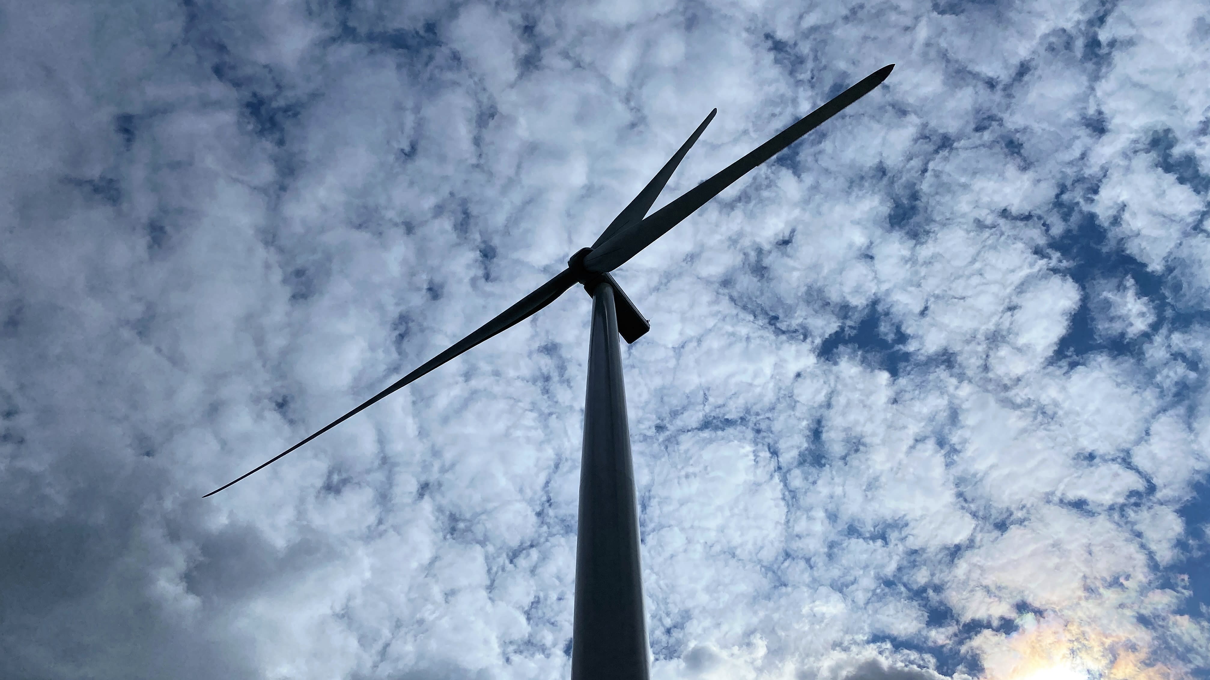 Tuulivoimalan siivet kuvattuna taivasta vasten Tyrinselän tuulivoimapuistossa