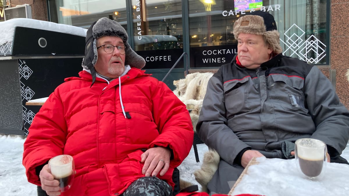Kaksi miestä istuu ulkona talviterassilla katsomassa Tunturirallia.