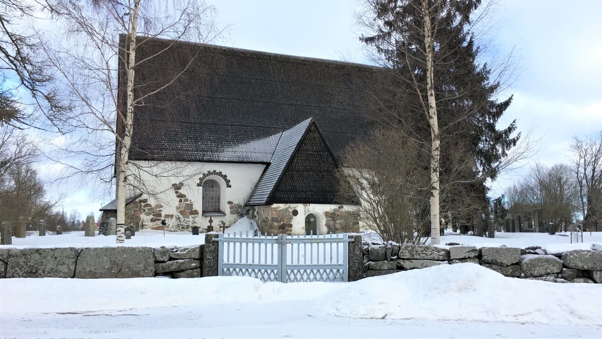 Isonkyrön vanha kirkko talvimaisemassa kuvattuna muurin ulkopuolelta.