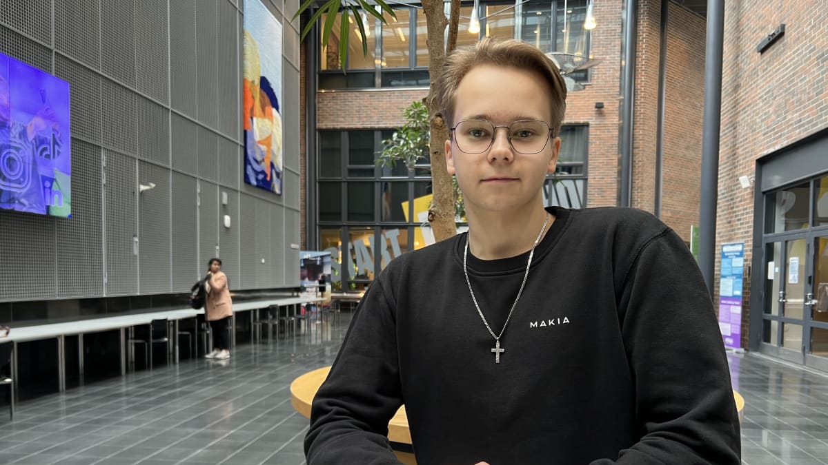 Liiketalouden opiskelija Tomi Karhu seisoo opiskelupaikkansa Haaga-Helian aulassa.