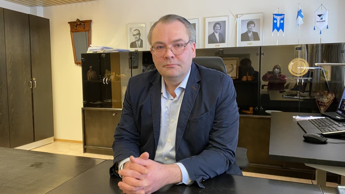 Kannuksen kaupunginjohtaja Jussi Niinistö istuu työpöytänsä ääressä ja katsoo kameraan.