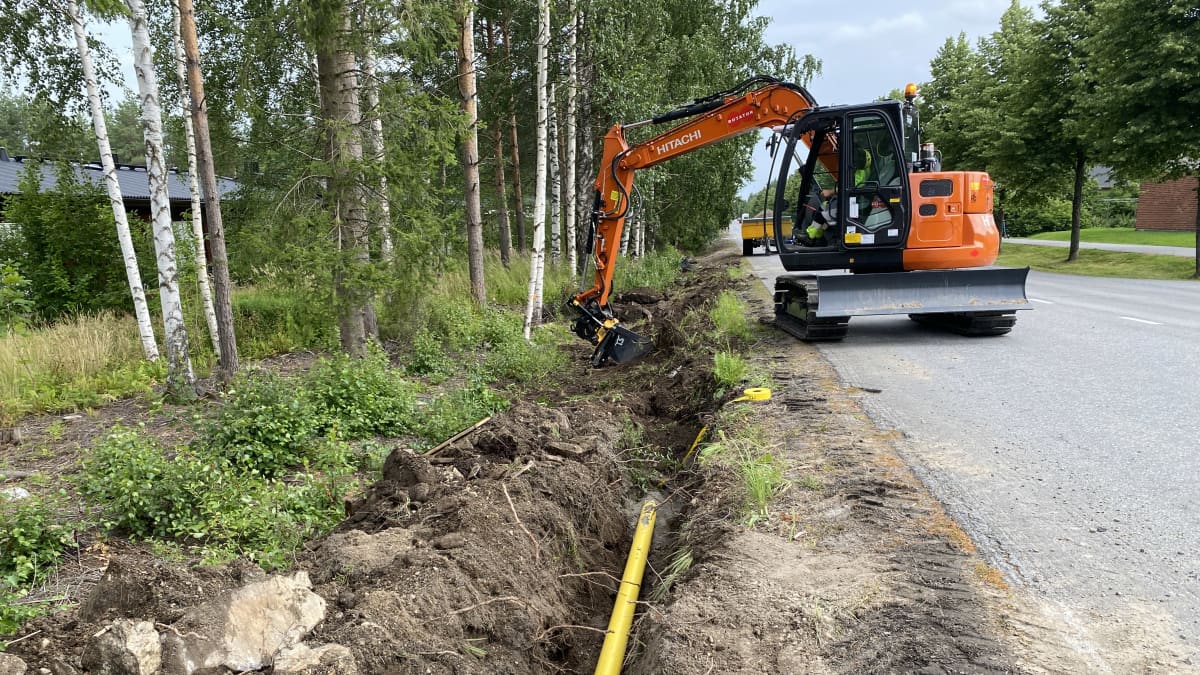 Kaivuri kaivaa maahan valokuitukaapelille ojaa.
