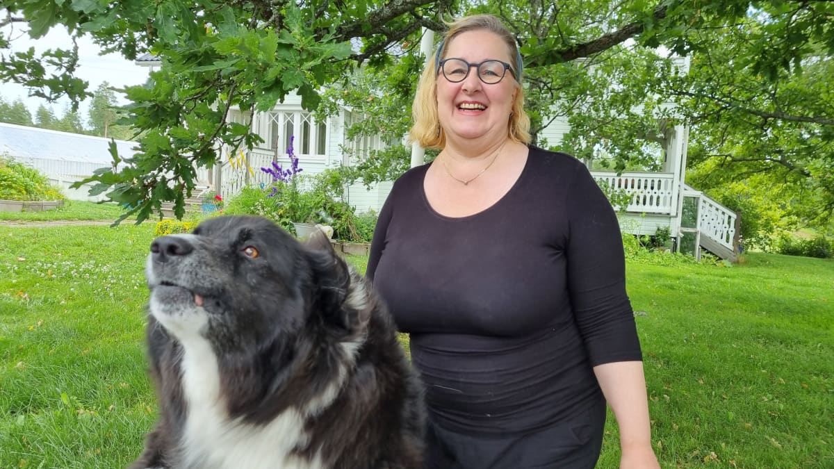 Mari Laakso-Suutari kotipihallaan Cara-koiran kanssa.
