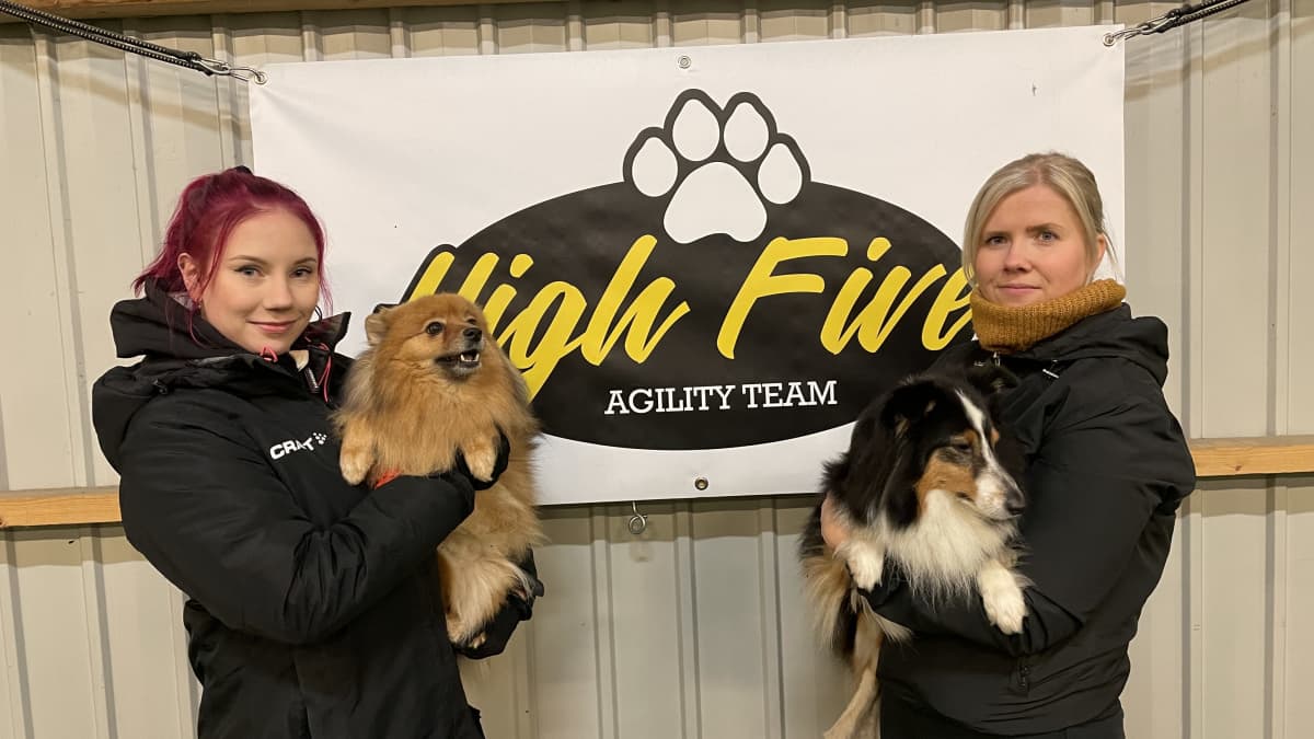 Hanna-Mari Mustosella ja Jenni Mustosella on sylissä agility-koirat Myy ja Ruu.