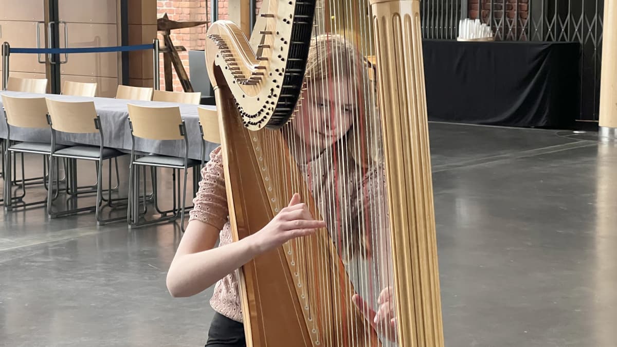 15-vuotias Viena Jylhä-Ollila soittaa harppua Sibeliustalon Metsähallissa. Vienan kasvot näkyvät harpun kielien takaa. Viena valittiin soittamaan Sinfonia Lahden nuorten solistien konserttiin tammikuussa 2023.