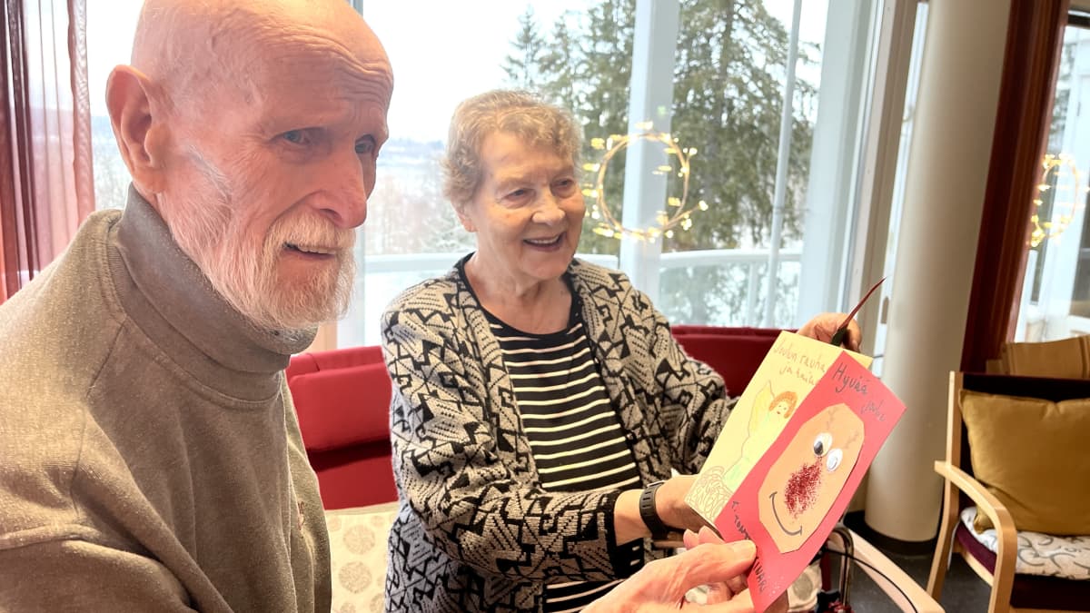 Kosti Mäkinen ja Raija Perkiö katsovat joulukortteja Sointu Senioripalveluiden Kuuselakeskuksessa Tampereen Härmälässä.