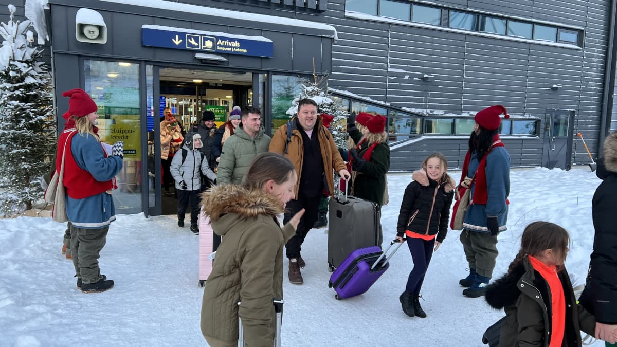 Matkailijoita saapumassa Rovaniemelle lentoaseman ovesta.