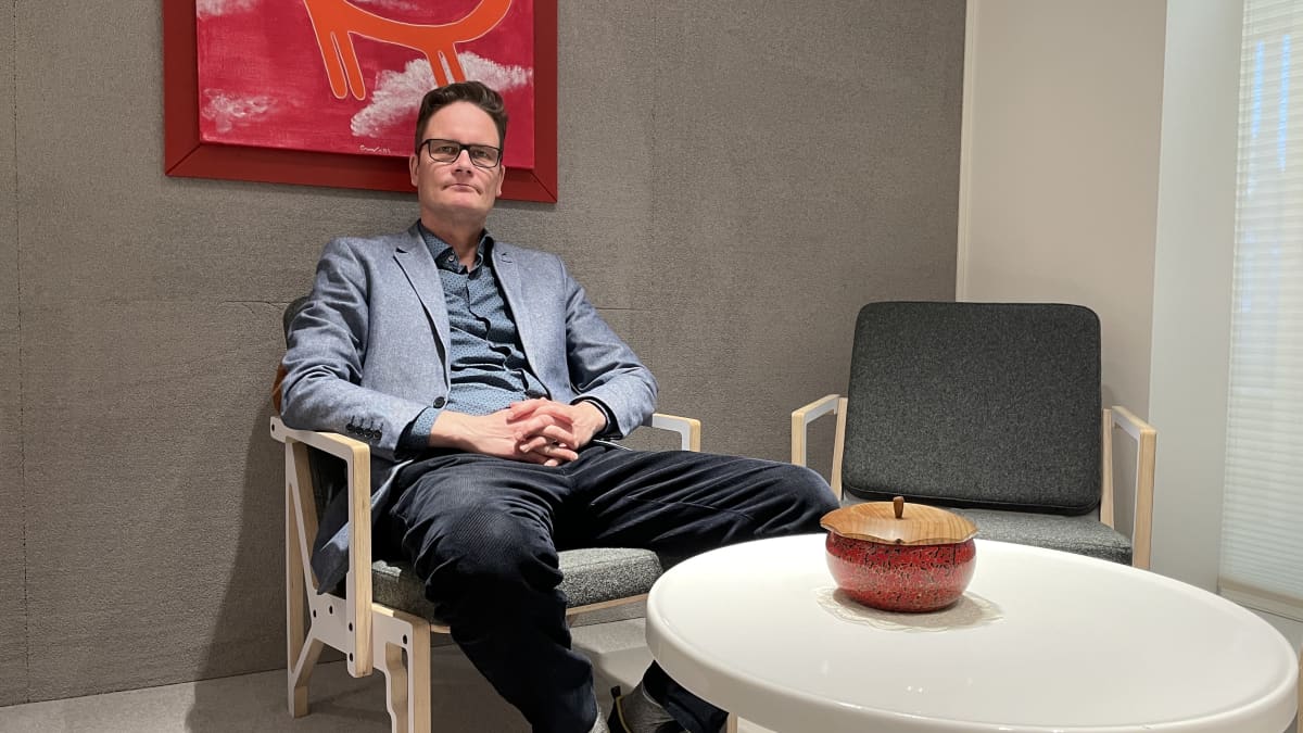 Mies istuu nojatuolissa työhuoneessaan.