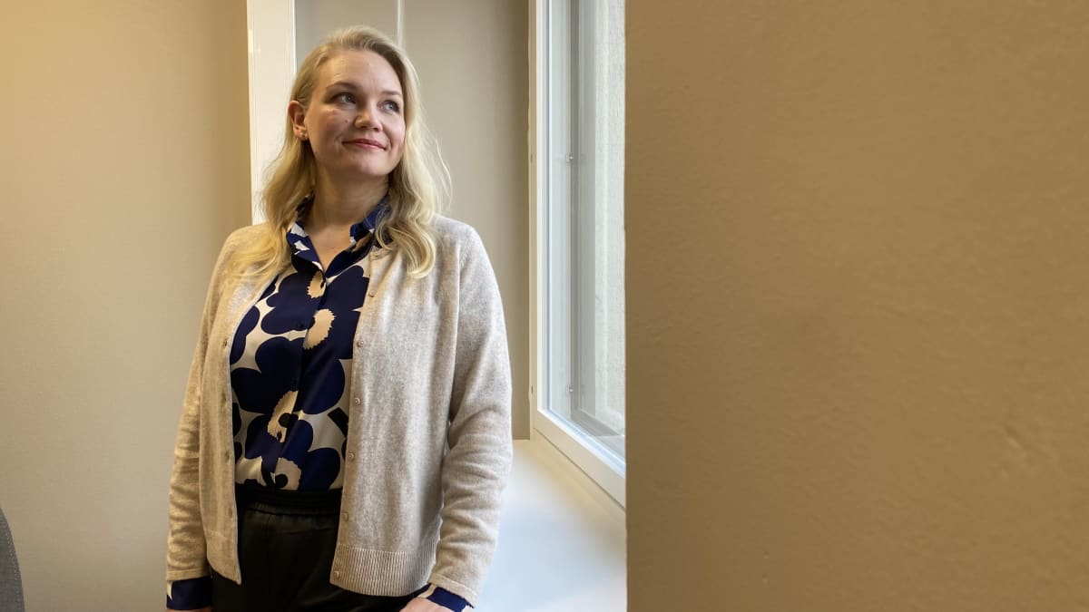 Salla Rikander nojaa ikkunalautaan ja katsoo kohti ikkunaa.
