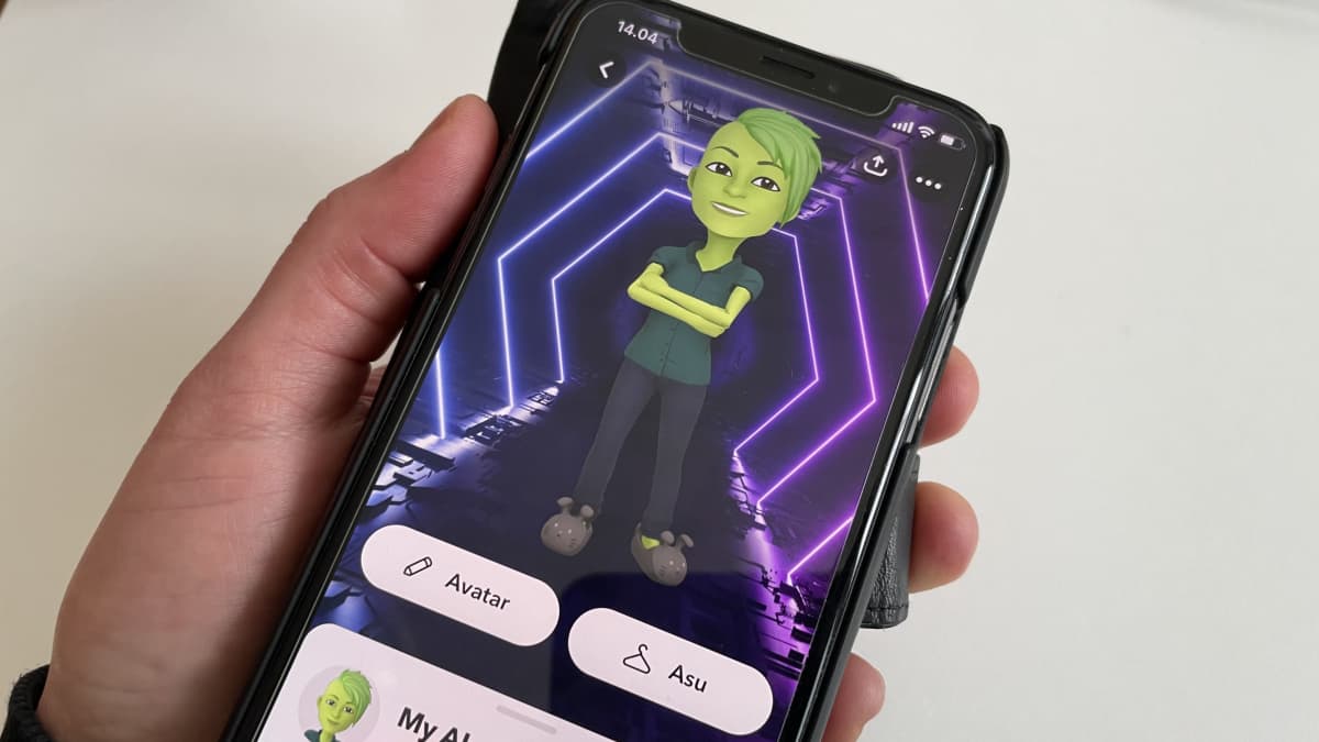 Kädessä on älypuhelin, jonka näytöllä näkyy Snapchatin virtuaaliystävä My AI