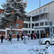 Ihmiset jonottavat korona- ja influenssarokotuksiin Tuiran hyvinvointikeskuksen edessä Oulussa.
