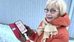 Eeva Piirainen katsoo kameraan ja pitelee kädessään matkapuhelinta, jonka näytöllä lukee: Pirkanmaan hyvinvointialue, Verkkosivuillamme on tekninen häiriö.