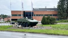 Patrian tehdasalueen sisäänkäynnin edustaa Hämeenlinnssa. Päärakennuksen edessä on kahdeksanpyöräinen panssariajoneuvo, sen takana kolme Patrian lippusalkoa.